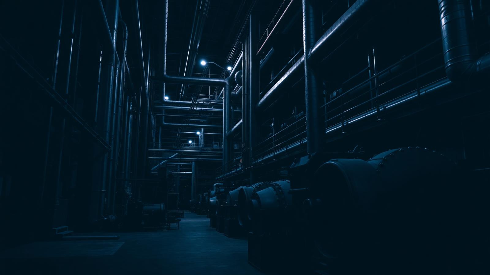 Interior de planta industrial moderna iluminada por luz fria, simbolizando indústria conectada ao digital.